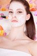 Junge brunette Frau bei einer pflegenden Gesichtsmaske mit Kosme