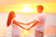 Romantic couple lovers holding hands, beach sunset