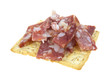 Cut pieces of sopressata on wheat cracker