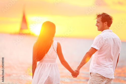 Photo: Couple in love happy at romantic beach sunset Couple in love happy at romantic beach sunset