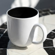 Photo: White coffee cup stands on round table White coffee cup stands on round table