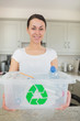 Woman holding full recycling bin