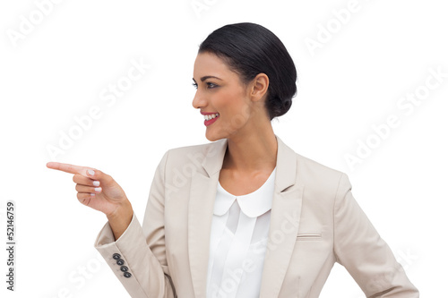 Photo: Profile view of a smiling businesswoman pointing Profile view of a smiling businesswoman pointing