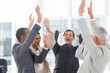 Group of smiling business people raising their hands