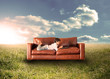 Photo: Child using laptop on couch in field Child using laptop on couch in field