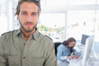Man standing in creative office with arms folded