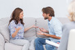 Couple arguing while the therapist is listening to them