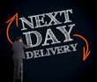 Businessman on ladder writing next day delivery