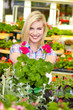 Woman shopping for and looking at plants in garden center