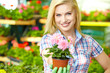 Woman shopping for and looking at plants in garden center