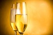 two flutes of champagne with golden bubbles and white foam