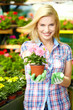 Photo: Woman shopping for and looking at plants in garden center Woman shopping for and looking at plants in garden center