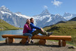 Travelers on a bench enjoying Alpine panorama. Jungfrau region,