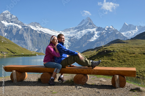Photo: Travelers on a bench enjoying Alpine panorama. Jungfrau region, Travelers on a bench enjoying Alpine panorama. Jungfrau region,