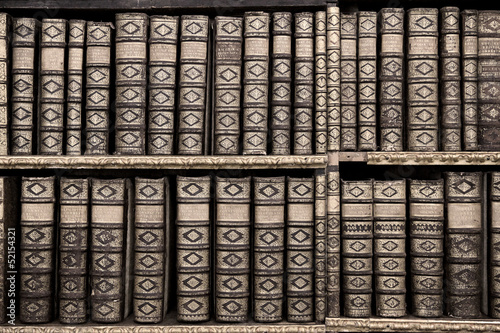 Photo: Old books in a library - sepia image Old books in a library - sepia image