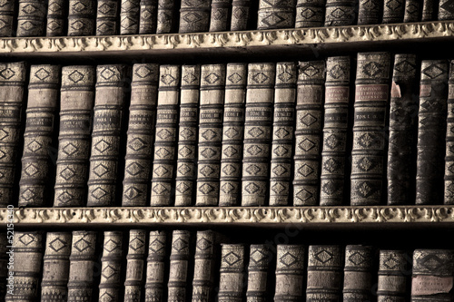 Photo: Old books in a library - sepia image Old books in a library - sepia image