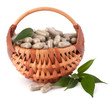 Herbal drug capsules in wicker basket. Alternative medicine conc
