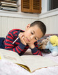 Elementary school age Boy Reading in Bed with Workbook