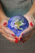 Foto: Women's hands holding the earth. Women's hands holding the earth.