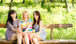 Three attractive girls on a wooden bench