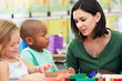 Elementary Pupils Counting With Teacher In Classroom