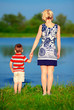 Photo: young woman and baby boy holding hands on lake young woman and baby boy holding hands on lake