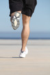 Unfocused man legs running on the concrete of a seafront