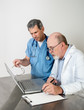 Photo: Two Senior Doctors at Laptop Computer Talking Two Senior Doctors at Laptop Computer Talking