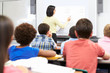 Photo: Teacher Standing In Class Using Interactive Whiteboard Teacher Standing In Class Using Interactive Whiteboard