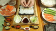 Making Sushi roll with crab meat and sesame seeds