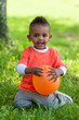 Outdoor portrait of a cute young  little black boy playing with