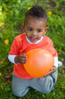 Outdoor portrait of a cute young  little black boy playing with