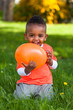 Outdoor portrait of a cute young  little black boy playing with