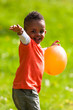 Outdoor portrait of a cute young  little black boy playing with