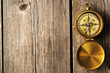 Antique compass over wooden background