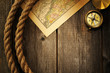 Antique compass and rope over old map