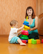 Happy mother and baby plays with toys