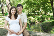 Pregnant wife and her husband in park with copy space