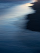 Ondas y reflejos del mar en la playa al atardecer