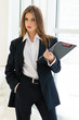 Businesswoman in man's suit & shirt at her office fashion styled