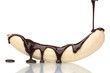 Banana poured with liquid chocolate isolated on white.