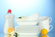 empty clean plates and cups with dishwashing liquid and lemon