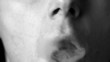 Man blowing smoke rings in black and white