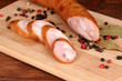 Tasty sausage on chopping board on browm background