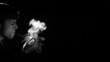 Man lighting cigarette on black background