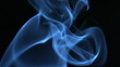 Blue smoke rising on black background