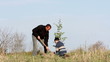 Father and son planting a tree.