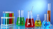 Test tubes with colorful liquids on blue background