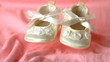 White booties falling on pink blanket