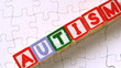 Autism letter blocks falling onto jigsaw surface